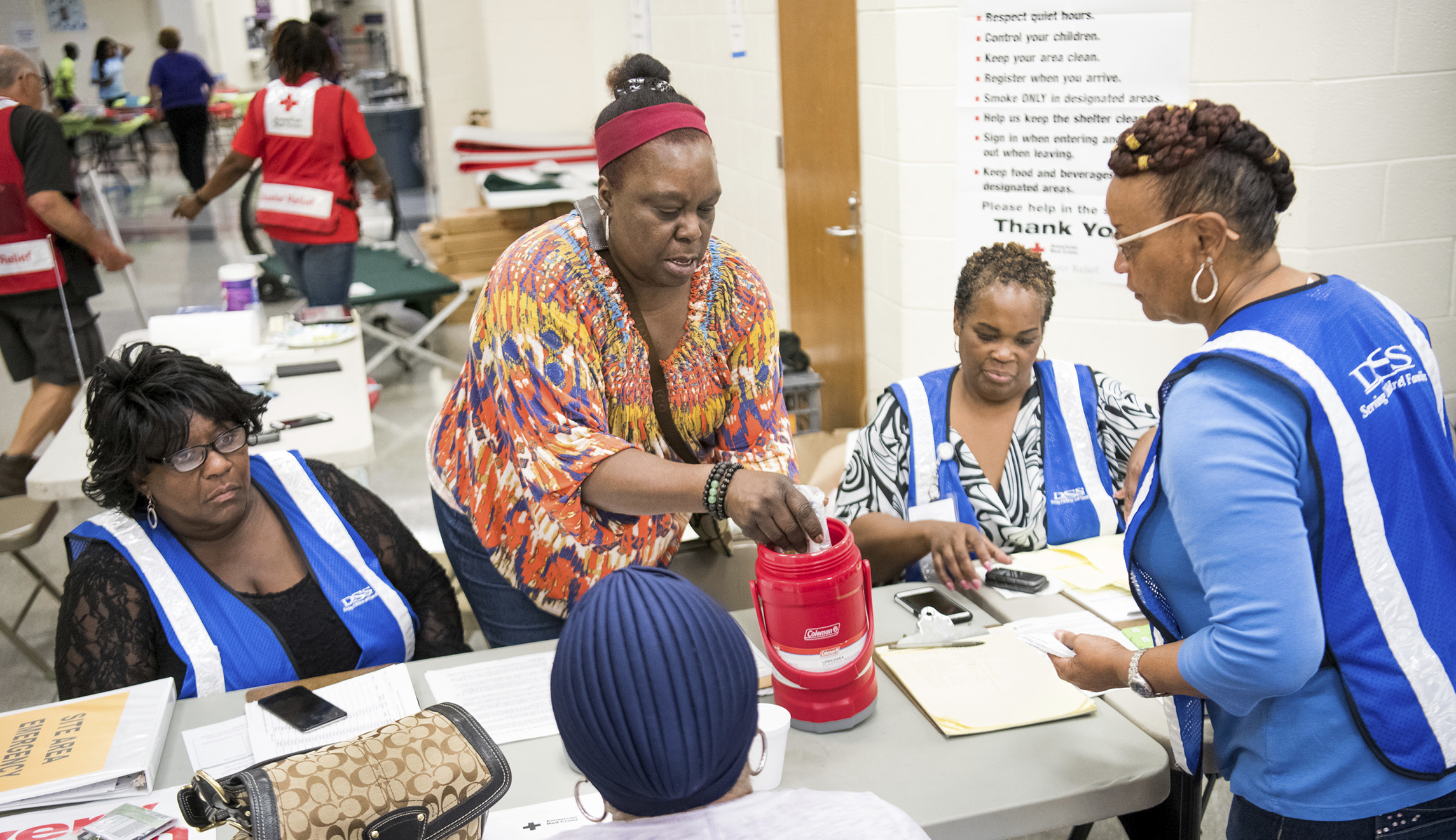 Social Service workers help an evacuee with her medications at a storm shelter at Ridge View High School as Hurricane Florence slowly moves across the the East Coast Friday in Columbia, S.C.