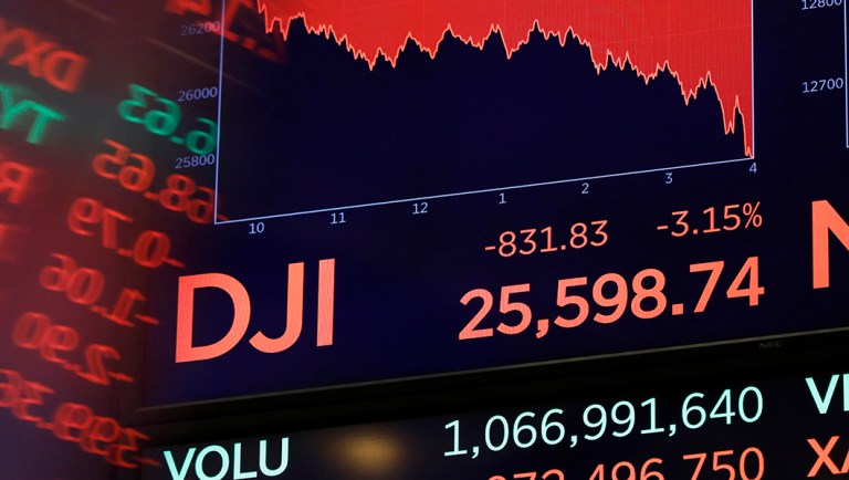 A screen above the floor of the New York Stock Exchange shows the closing number of the Dow Jones industrial average.