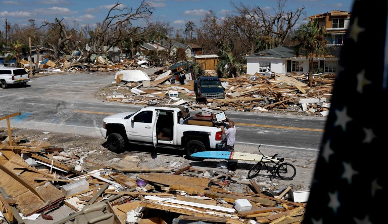 William Johnson helps pack up a friend's belongings as he returns to his damaged home from hurricane Michael in Mexico Beach, Fla., Sunday, Oct. 14, 2018.
