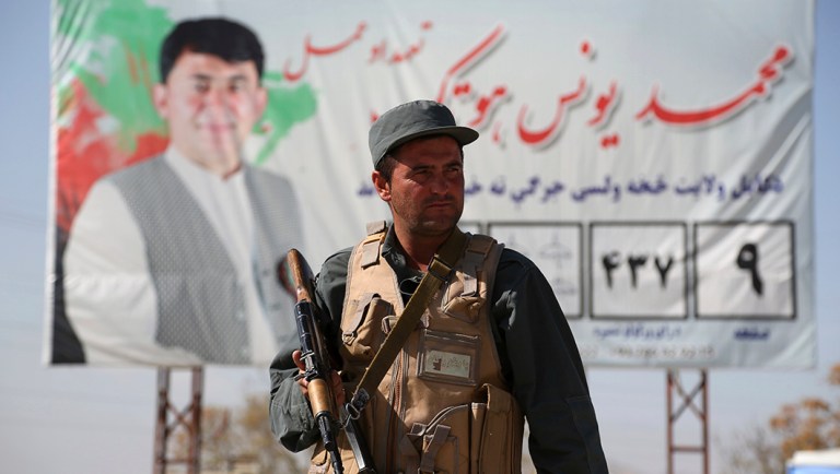 Afghan police stand guard at a checkpoint ahead of parliamentary elections.