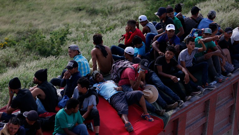 Migrants hitch a ride on the back of a truck as a thousands-strong caravan of Central Americans hoping to reach the U.S. border moves onward from Juchitan, Oaxaca state, Mexico, Thursday, Nov. 1, 2018. Thousands of migrants resumed their slow trek through southern Mexico on Thursday, after attempts to obtain bus transport to Mexico City failed.