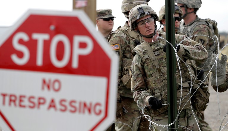 Members of the U.S Army place razor wire for a temporary encampment for the troops near the U.S.-Mexico International bridge, Sunday, Nov. 4, 2018, in Donna, Texas.