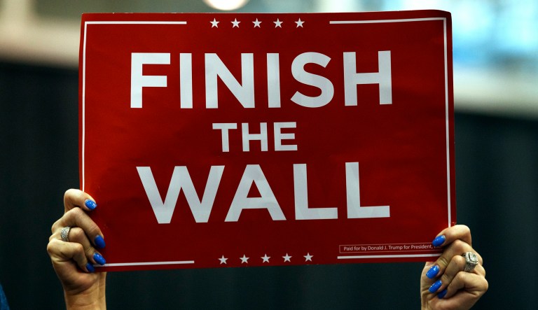 A supporter of President Trump hold up a sign that reads "Finish the Wall" during a rally at the IX Center, in Cleveland, Monday, Nov. 5, 2018.
