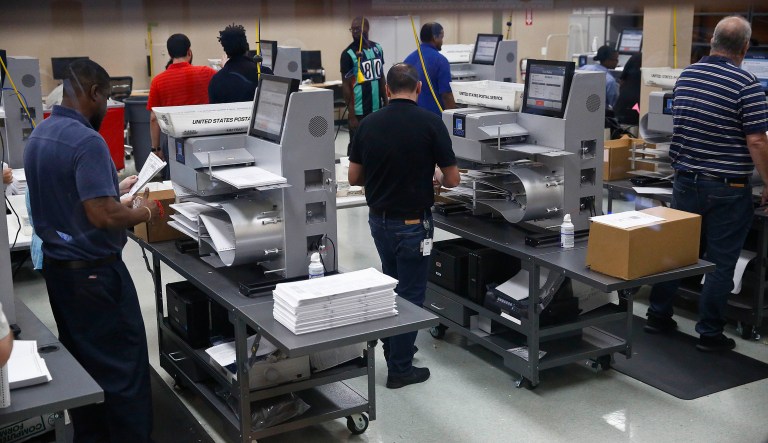 Workers load ballots into machines at the Broward County Supervisor of Elections office during a recount on Sunday, Nov. 11, 2018, in Lauderhill, Fla.