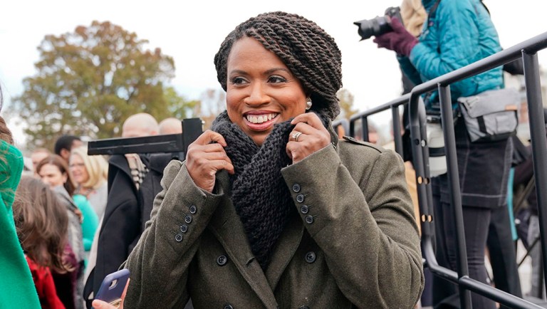 Rep.-elect Ayanna Pressley, D-Mass., adjusts her coat after posing with other members of the freshman class of Congress.