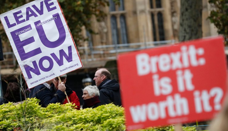 Pro and anti Brexit protesters hold placards as they vie for media attention near Parliament in London, Friday, Nov. 16, 2018.  Britain's Prime Minister May still faces the threat of a no-confidence vote, after several Conservative Party lawmakers said they had written letters asking for one.