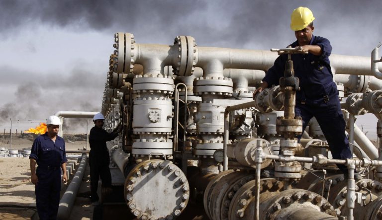In this Dec. 13, 2009 photo, Iraqi laborers work at the Rumaila oil refinery in Zubair near the city of Basra, Iraq.