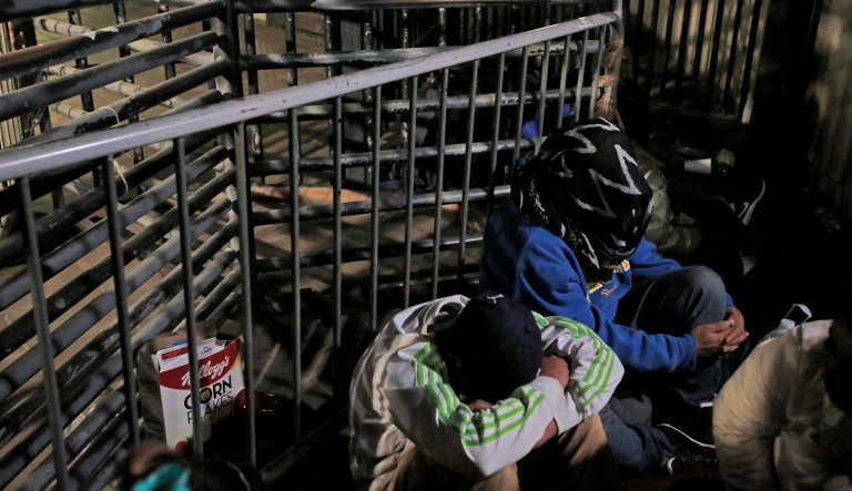 Honduran asylum seekers cover their faces at San Diego's Otay Mesa port of entry seen from Tijuana, Mexico, Monday, Dec. 17, 2018.
