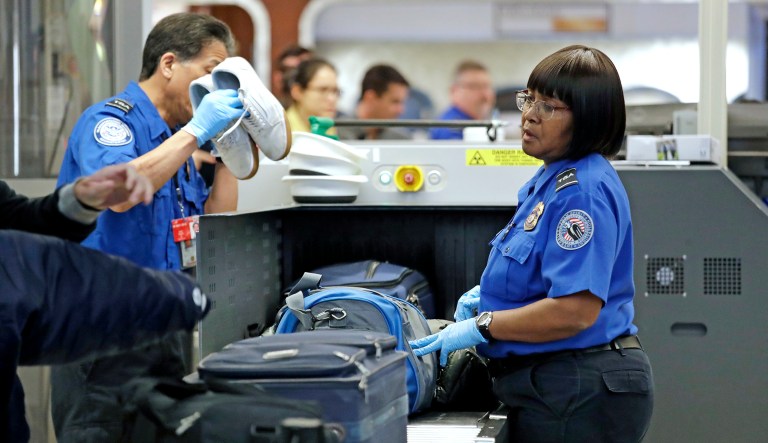Transportation Security Administration (TSA) officers assist travelers with luggage through a security screening area during a partial federal government shutdown Monday, Dec. 31, 2018, in SeaTac, Wash. TSA staff are among tens of thousands of federal employees considered essential as the federal government shutdown moves into its second week. They are working without pay until the shutdown ends, but will likely be paid retroactively later on.