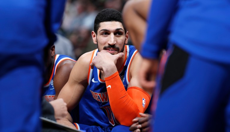 New York Knicks center Enes Kanter jokes with teammates during a timeout the first half of the team's NBA basketball game against the Denver Nuggets on Tuesday, Jan. 1, 2019, in Denver.