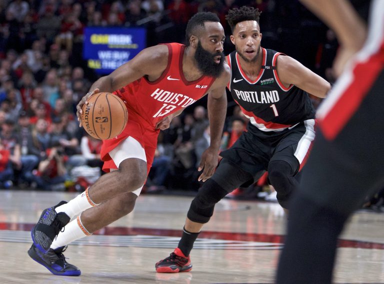 Houston Rockets guard James Harden, left, dribbles past Portland Trail Blazers guard Evan Turner during the first half of an NBA basketball game in Portland, Ore., on Jan. 5.