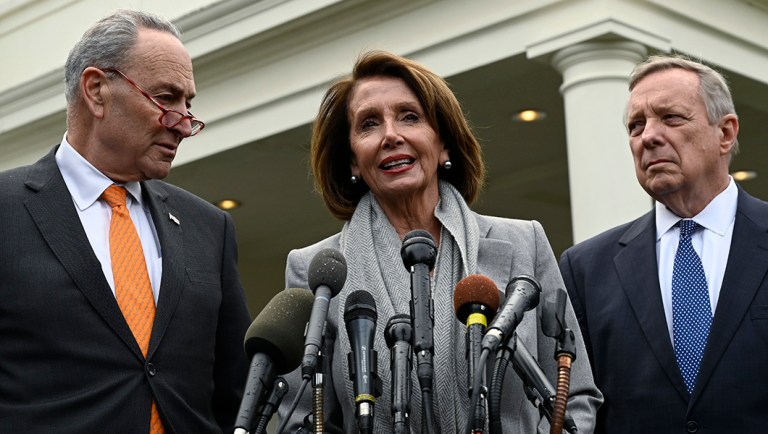 House Speaker Nancy Pelosi of Calif., center, standing with Senate Minority Leader Sen. Chuck Schumer of N.Y., left, and Sen. Dick Durbin, D-Ill., right, speak with reporters.