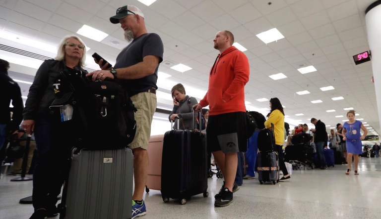 Passengers wait in line at Sun Country Airlines in Terminal G at Miami International Airport in Miami.