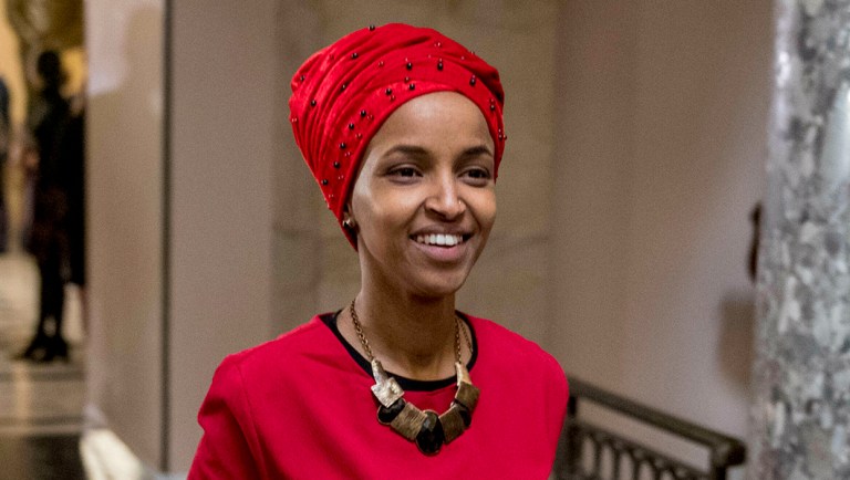 Rep. Ilhan Omar, D-Minn., center, walks through the halls of the Capitol Building in Washington