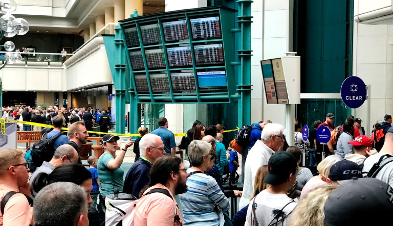 People wait to get through security at the Orlando International Airport following a security incident on Saturday.