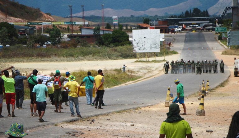 Anti-government protesters face Venezuelan National Guards standing in the border area that separates Pacaraima, Brazil, from Santa Elena de Uairen, Venezuela.