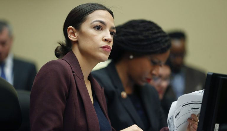Rep. Alexandria Ocasio-Cortez, D-N.Y., left, looks over her notes during testimony.