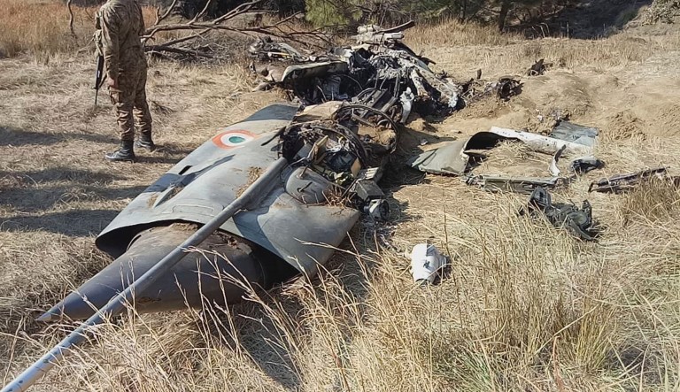 A Pakistani soldier stands guard near the wreckage of an Indian plane shot down by the Pakistan military on Wednesday, in Hurran, near the Line of Control in Pakistani Kashmir, Thursday, Feb. 28, 2019. 