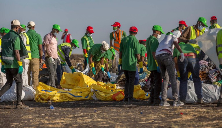 Workers collect clothes and other materials, under the instruction of investigators, at the scene where the Ethiopian Airlines Boeing 737 Max 8 crashed shortly after takeoff on Sunday killing all 157 on board, near Bishoftu, or Debre Zeit, south of Addis Ababa, in Ethiopia.