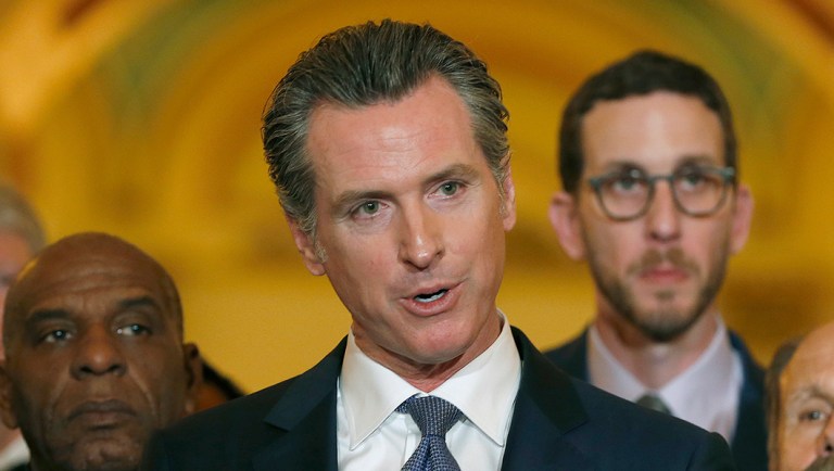 Flanked by lawmakers, Gov. Gavin Newsom discusses his decision to place a moratorium on the death penalty.