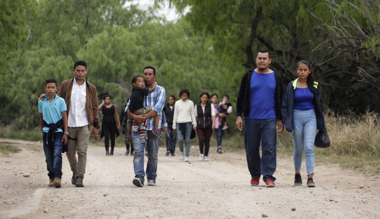 In this Thursday, March 14, 2019, photo, a group of migrant families walk from the Rio Grande, the river separating the U.S. and Mexico in Texas, near McAllen, Texas. 