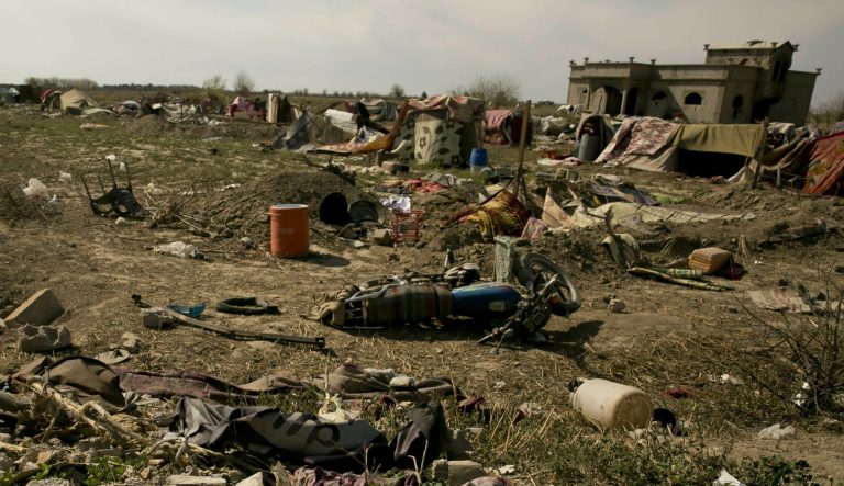 An Islamic State militant flag, foreground ,lies in a tent encampment after U.S.-backed Syrian Democratic Forces (SDF) fighters took control of Baghouz, Syriaon Saturday, March 23, 2019.  The elimination of the last Islamic State stronghold in Baghouz brings to a close a grueling final battle that stretched across several weeks and saw thousands of people flee the territory and surrender in desperation, and hundreds killed. 