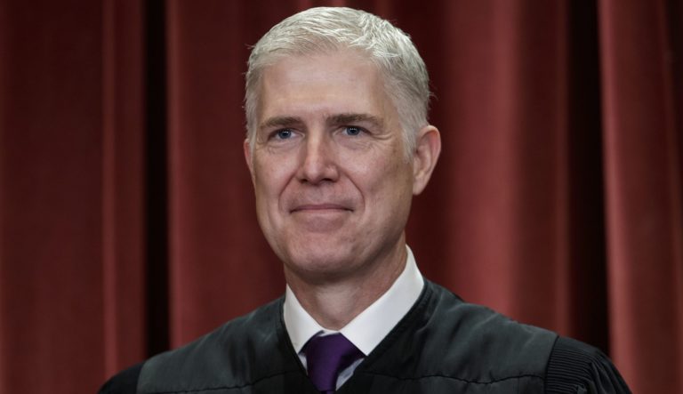 In this Nov. 30, 2018 photo, Associate Justice Neil Gorsuch, appointed by President Donald Trump, sits with fellow Supreme Court justices for a group portrait at the Supreme Court Building in Washington. 