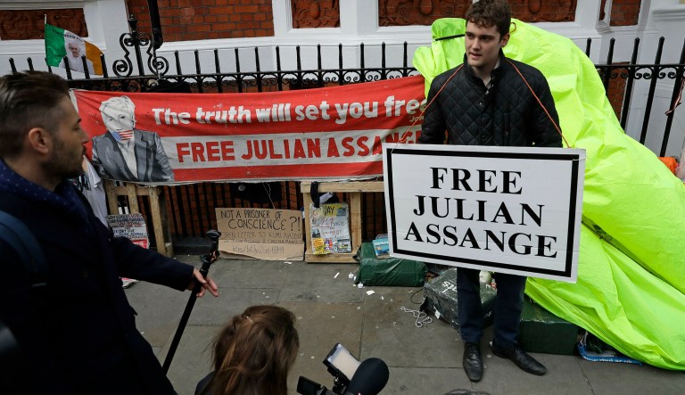 A protester holds a placard outside the Ecuadorian Embassy in London, after WikiLeaks founder Julian Assange was arrested by officers from the Metropolitan Police and taken into custody Thursday April 11, 2019. Police in London say they've arrested WikiLeaks founder Julian Assange at the Ecuadorean embassy on a court warrant dating back to 2012.