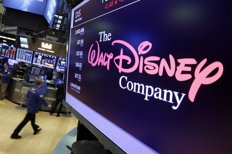FILE - In this Aug. 8, 2017, file photo, The Walt Disney Co. logo appears on a screen above the floor of the New York Stock Exchange. On Thursday, April 11, Disney is unveiling details of its long-awaited streaming service Disney Plus. 