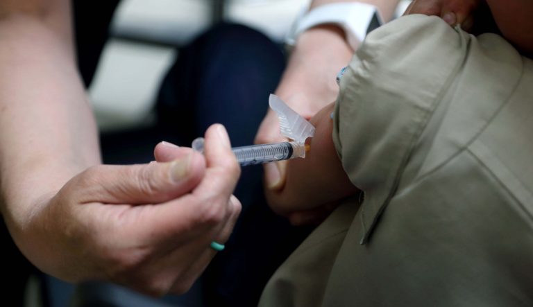 In this Friday, May 17, 2019 photo, Starr Roden, left, a registered nurse and immunization outreach coordinator with the Knox County Health Department, administers a vaccination to Jonathan Detweiler, 6, at the facility in Mount Vernon, Ohio.
