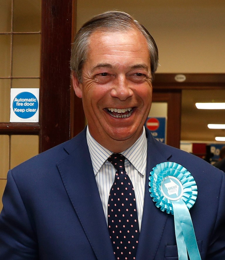 Brexit Party leader Nigel Farage smiles as he arrives at the counting center for the European Elections.