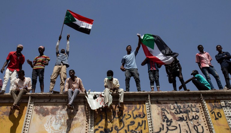 Sudanese protesters wave national flags at the sit-in outside the military headquarters in Khartoum, Sudan.