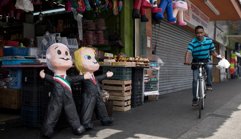 A man rides a bicycle next to a local market selling piÃ±atas of Mexican President Andres Manuel Lopez Obrador and US President Donald Trump, in Tijuana, Mexico, Saturday, June 8, 2019.