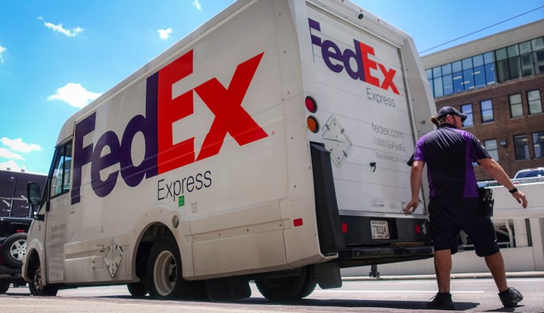 A FedEx delivery truck is loaded by an employee on the street, Tuesday, June 25, 2019, in downtown Cincinnati. FedEx Corp. (FDX) on Tuesday reported a fiscal fourth-quarter loss of $1.97 billion, after reporting a profit in the same period a year earlier.