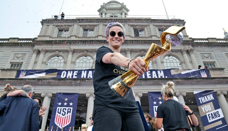The U.S. women's soccer team member Megan Rapinoe holds the championship trophy at City Hall after a ticker tape parade in New York.