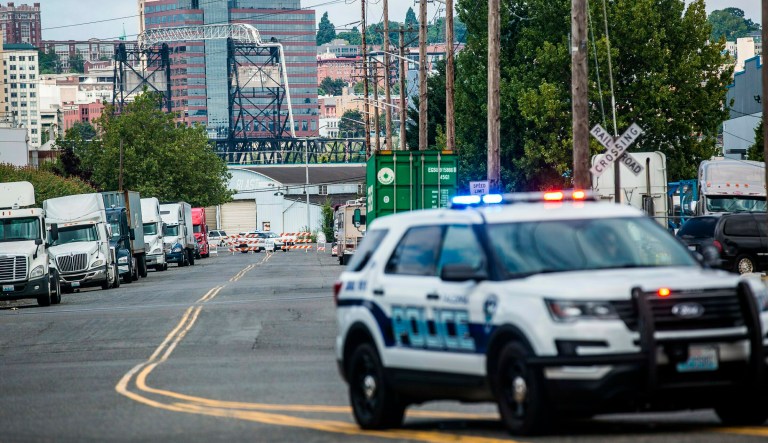 A police officer guards the front of a road block near the Northwest Detention Center, Saturday, July 13, 2019 in Tacoma, Wash.