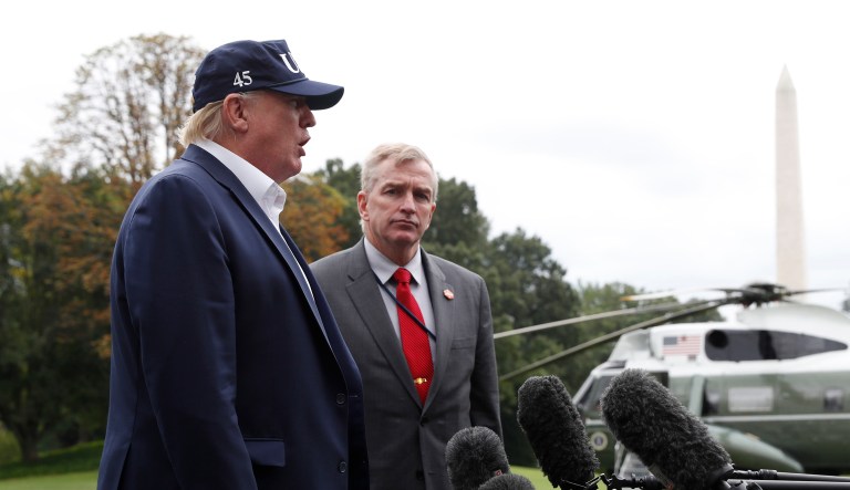 President Trump (left) speaks to the media with Coast Guard Rear Adm. Peter Brown as they return to the White House from Camp David, Sunday, Sept. 1, 2019, in Washington.