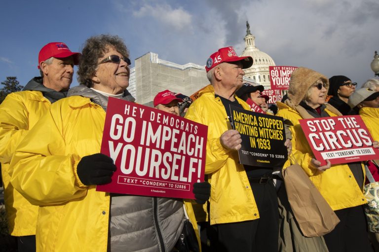 Colleen Deaver of Pasadena, Md., left, joins a rally led by the House Freedom Caucus in support of President Donald Trump, Wednesday on Capitol Hill in Washington.