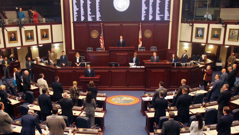 Members of the House of Representatives rise for prayer at the opening of a special session.