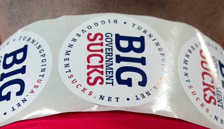 A member of Turning Point USA wears "Big Government Sucks" stickers around his neck during the Conservative Political Action Conference in National Harbor, Md.