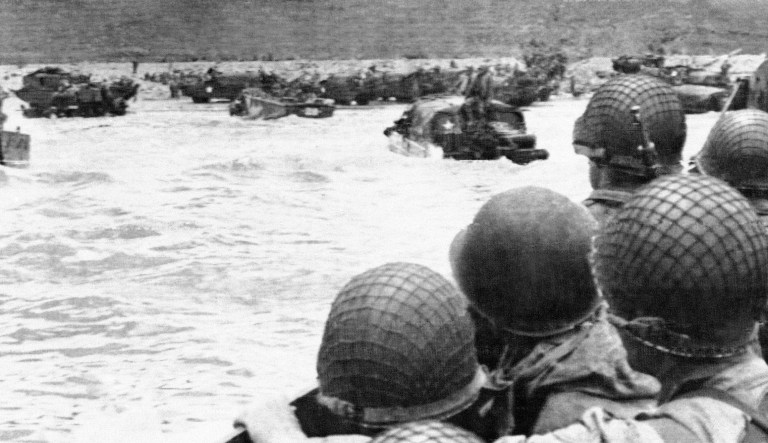 Landing craft coming in to a beach in France on June 7, 1944, set American fighting men down on the continent for the invasion of Fortress Europe, as their comrades already landed form on the shore.