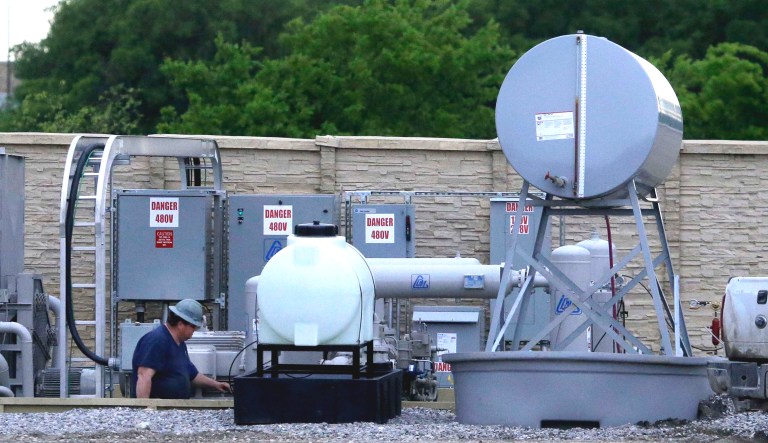 A worker examines components of a hydraulic fracturing well in Mansfield, Texas.