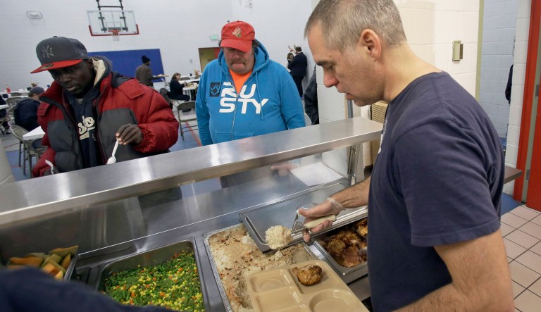 In this Nov. 14, 2013 photo, chef Jeff Ansorge serves up lunch at the Salvation Army Eastside Corp Community Center in St. Paul, Minn. Ansorge, who used to command a staff of 17 at a posh downtown Minneapolis restaurant making nearly $80,000 a year, gave it all up to become the cook in charge of a Salvation Army soup kitchen where the meals are free.