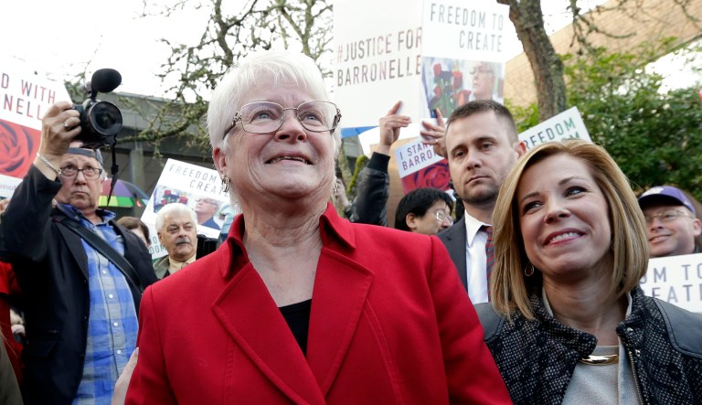 Barronelle Stutzman, left, a Richland, Washington, florist who was fined for denying service to a gay couple in 2013, smiles as she is surrounded by supporters after a hearing before Washington's Supreme Court, Tuesday, Nov. 15, 2016, in Bellevue, Wash. Stutzman was sued for refusing to provide services for a same sex-wedding and says she was exercising her First Amendment rights, but justices questioned whether ruling in her favor would mean other businesses could turn away customers based on racial or other grounds.