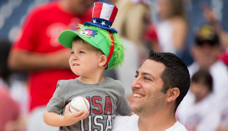 A father and son, who is wearing a Phillie Phanatic's hat, looks on prior to the first inning of a baseball game between the Atlanta Braves and the Philadelphia Phillies.