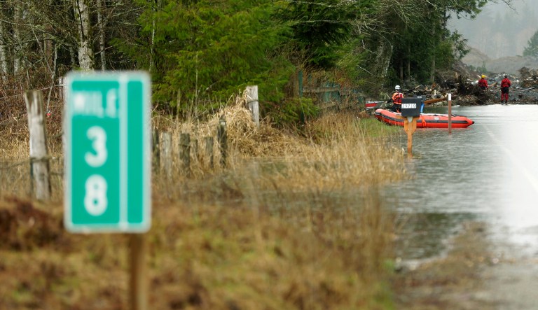 A mile marker is seen at left as flood water slowly recedes on Washington Highway 530.