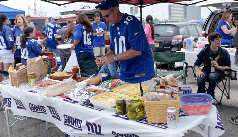 A fan prepares food while tailgating prior to an NFL football game in East Rutherford, N.J. 