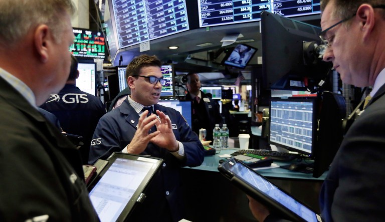 Specialist Robert Tuccillo, center, works with traders at his post on the floor of the New York Stock Exchange.