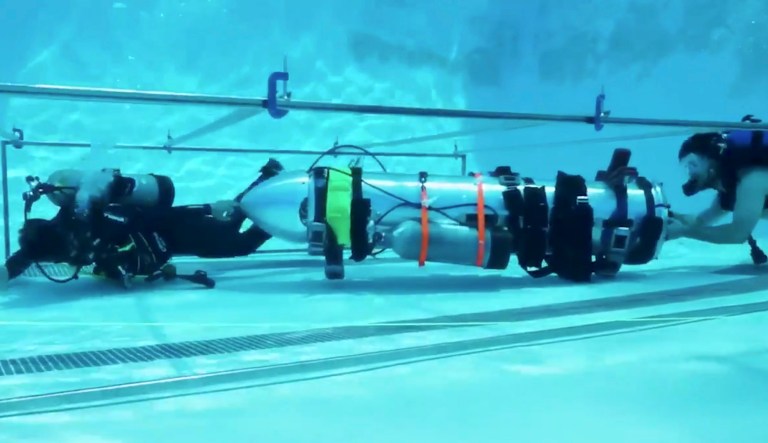 This frame grab from video tweeted by Elon Musk shows a "tiny kid-sized submarine" being tested in a pool at Palisades Charter High School in California. Musk's Space X rocket company tested the submarine that could potentially help rescue the remaining children and their coach trapped in a flooded cave in Thailand.
