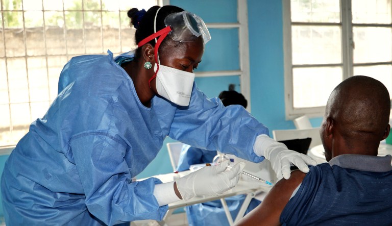 A healthcare worker from the World Health Organization gives an Ebola vaccination to a front line aid worker who will then go to vaccinate people who might potentially have the virus, in Mbandaka, Congo. 